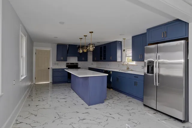 a kitchen with stainless steel appliances granite countertop a refrigerator and a stove top oven