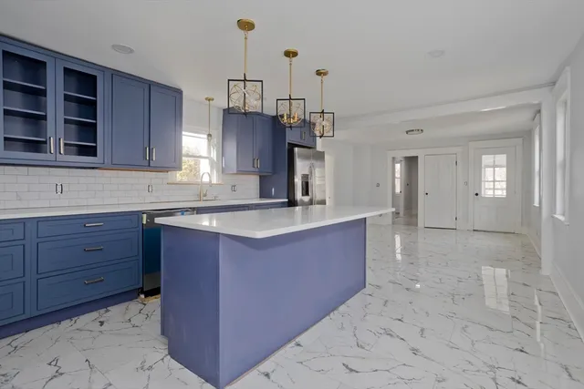 a kitchen with stainless steel appliances granite countertop a sink a stove and a refrigerator