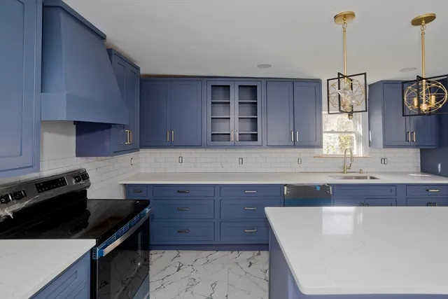 a kitchen with a sink a stove and wooden cabinets