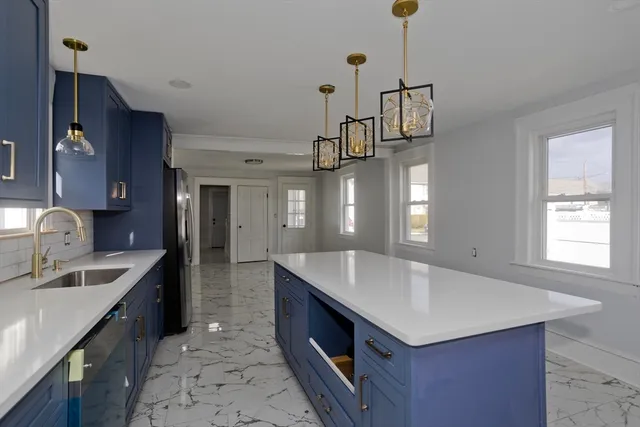 a kitchen with a sink a counter space and cabinets