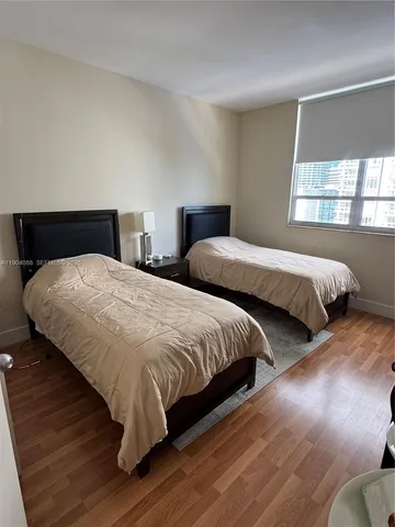 a bedroom with two beds and wooden floor