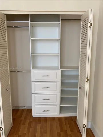 a view of walk in closet with empty racks