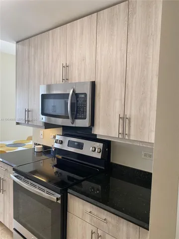 a kitchen with granite countertop a stove and a microwave