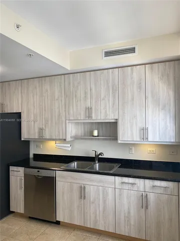 a kitchen with stainless steel appliances granite countertop a sink a stove and a refrigerator