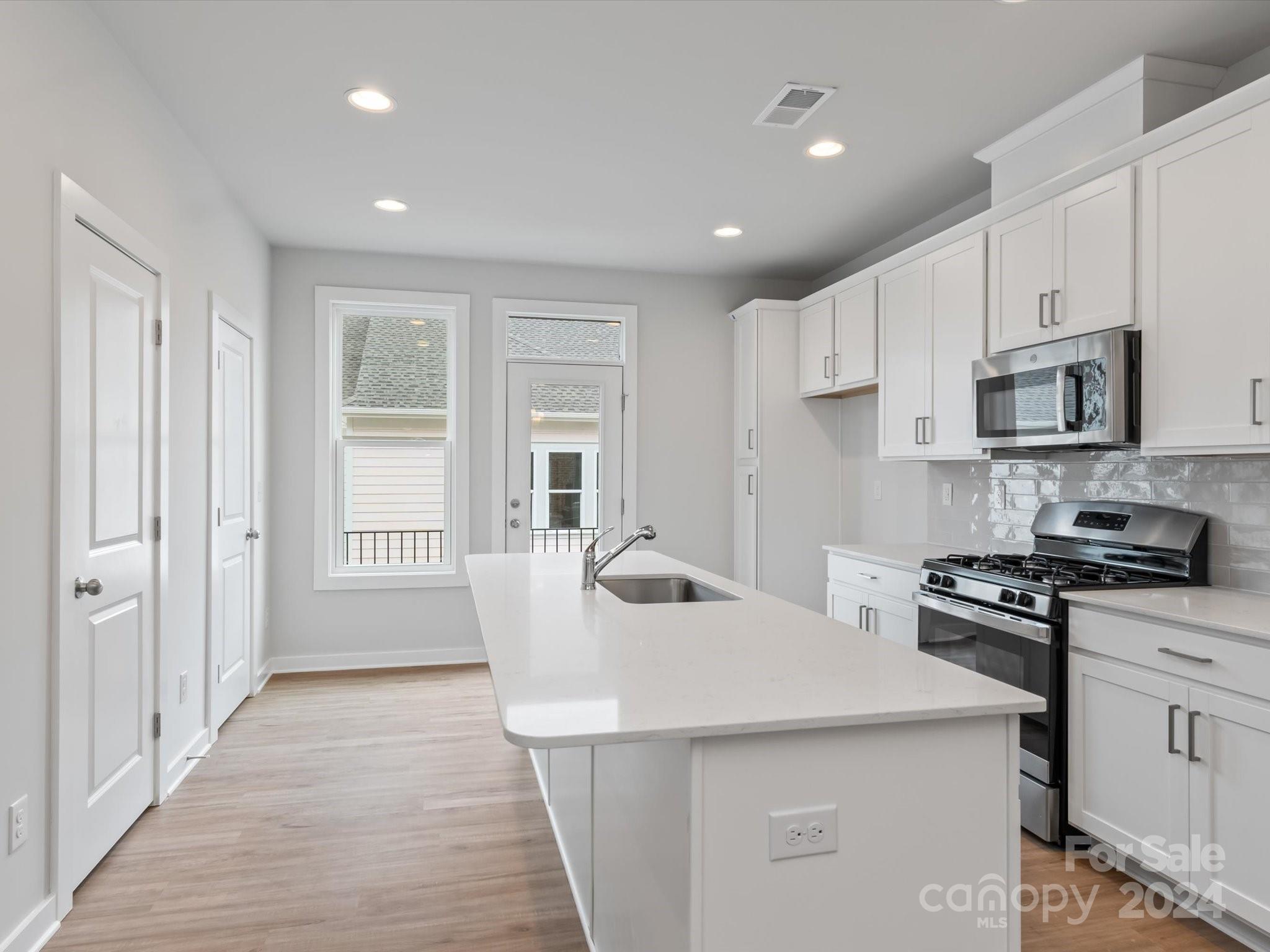 230 Gilead Road Huntersville, NC 28078 - Photo 2 of 19 a kitchen with kitchen island a sink stove and refrigerator