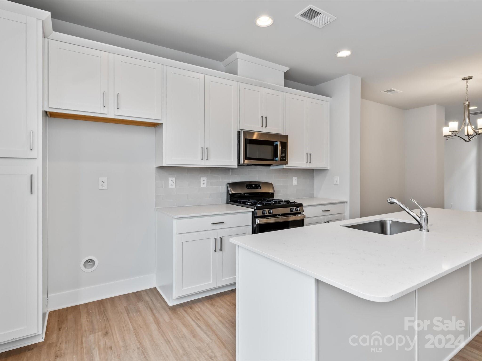 230 Gilead Road Huntersville, NC 28078 - Photo 6 of 19 a kitchen with stainless steel appliances a stove a sink a microwave and cabinets