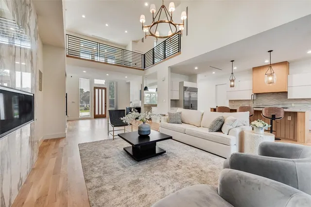 a living room with furniture kitchen view and a wooden floor
