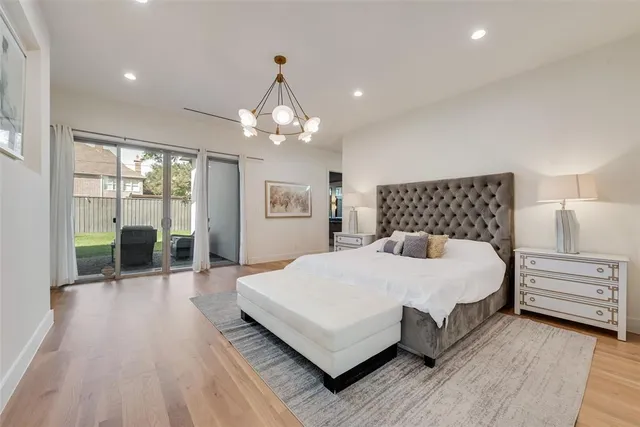 a bedroom with a large bed and a chandelier