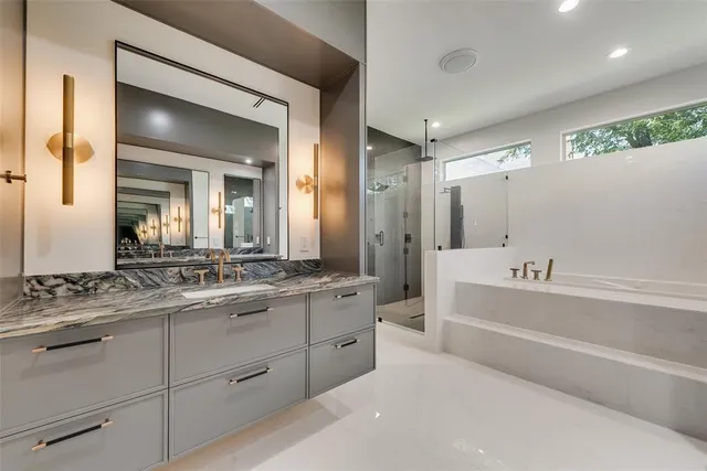 a bathroom with a granite countertop sink mirror and bathtub