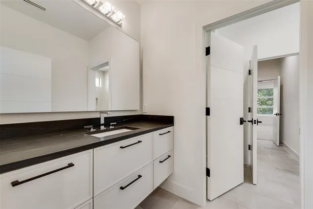 a bathroom with a granite countertop sink and a mirror