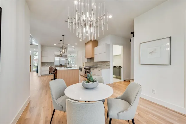 a view of a dining room with furniture a chandelier and wooden floor