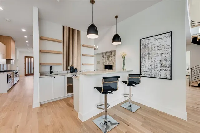 a kitchen with stainless steel appliances kitchen island granite countertop a stove a sink and white cabinets with wooden floor