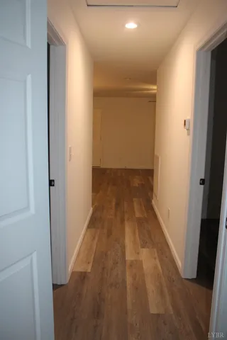 an empty room with wooden floor chandelier and window
