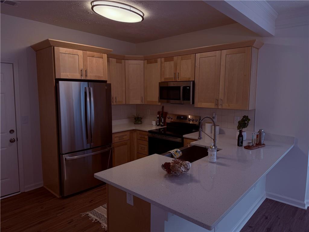 28 Hampton Drive Cartersville, GA 30121 - Photo 8 of 24 a kitchen with a refrigerator a stove a microwave and wooden cabinets
