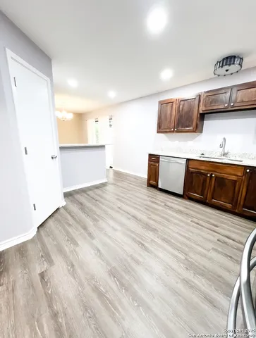 a view of kitchen with stainless steel appliances wooden cabinets and wooden floor