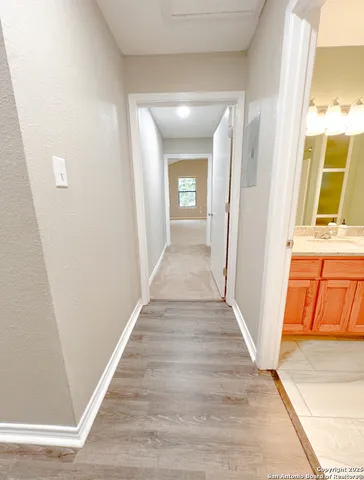 a view of a hallway with wooden floor and a living room