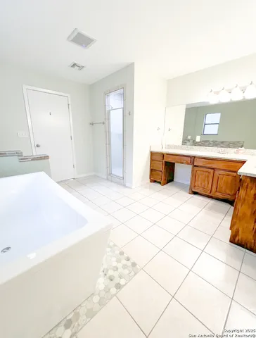 a spacious bathroom with a tub and mirror