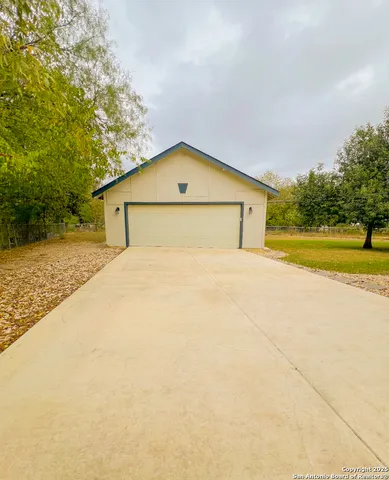a view of big house with a yard and large trees