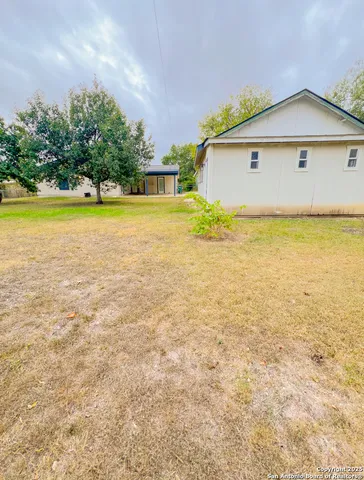 a view of an house with backyard space and balcony