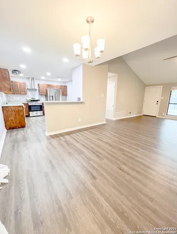 a view of a kitchen with kitchen island and stainless steel appliances