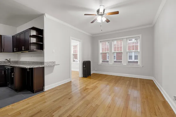 a view of an empty room with a window and wooden floor