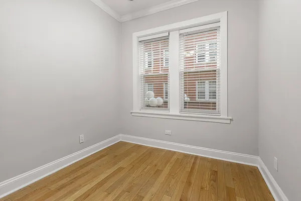 a view of a room with wooden floor and a window