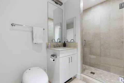a bathroom with a granite countertop sink a toilet and a mirror
