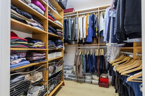 a view of walk in closet with clothes and shoes