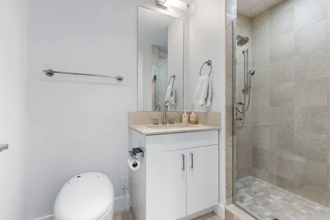a bathroom with a sink a toilet and shower