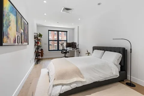 a bedroom with a large bed and two windows