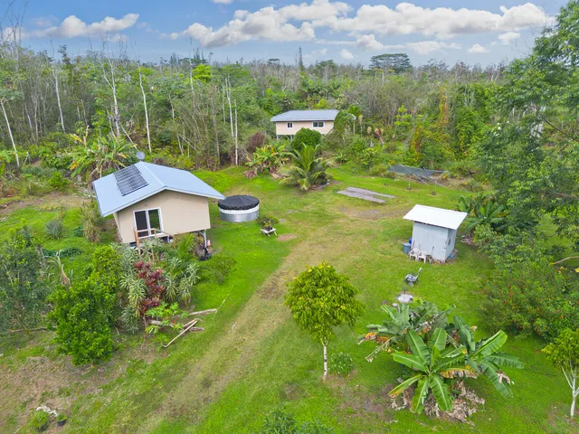 a aerial view of a house with a yard and a fountain
