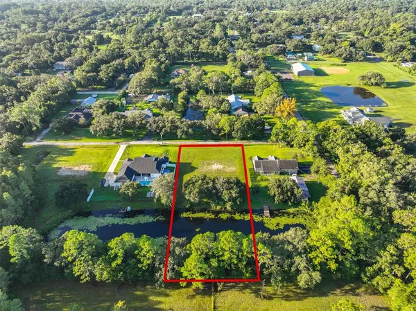 an aerial view of a house with a yard and lake view