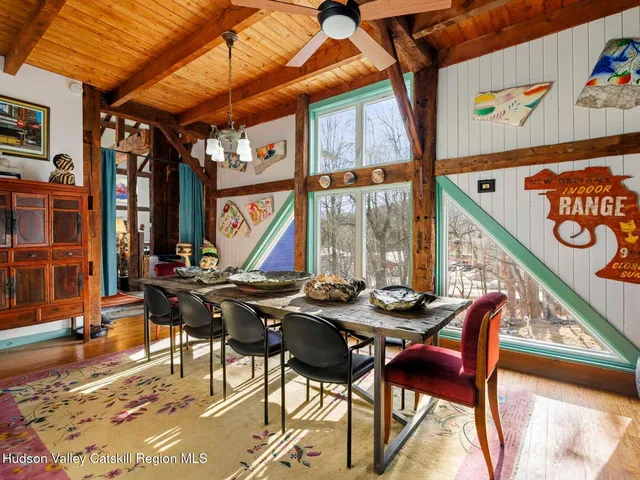 a living room with furniture a flat screen tv and a floor to ceiling window