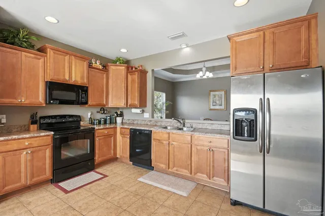 a kitchen with stainless steel appliances granite countertop a refrigerator and a stove top oven