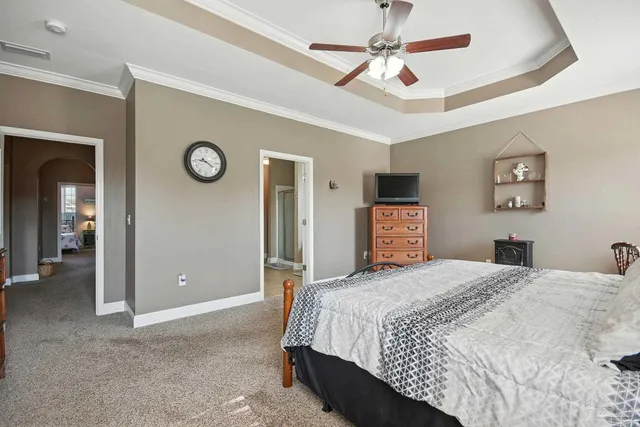 a bedroom with a bed and a ceiling fan