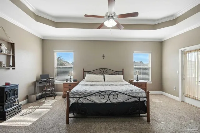 a bedroom with a bed a chandelier and a dresser