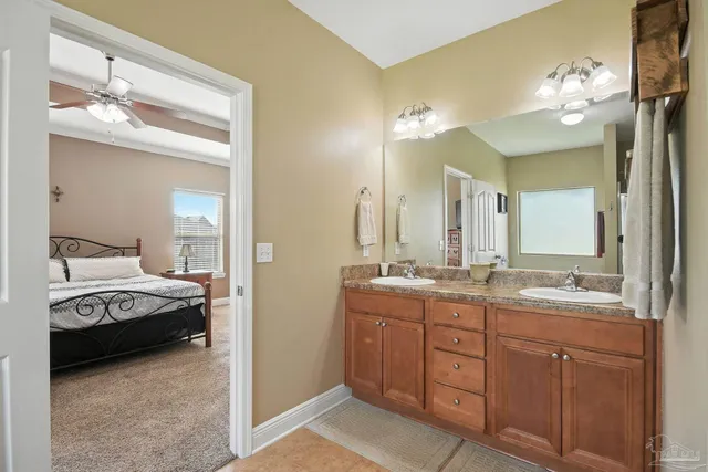a en suite bathroom with a granite countertop sink and a mirror