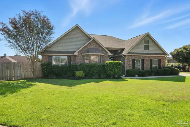 a front view of a house with yard and green space