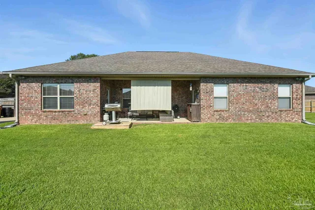 a backyard of a house with table and chairs
