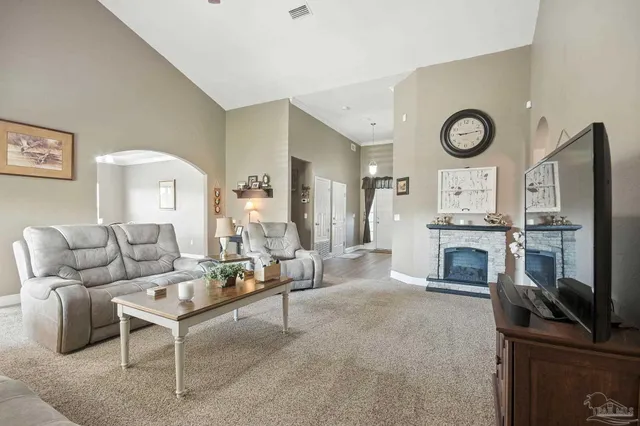 a living room with furniture a clock and a flat screen tv