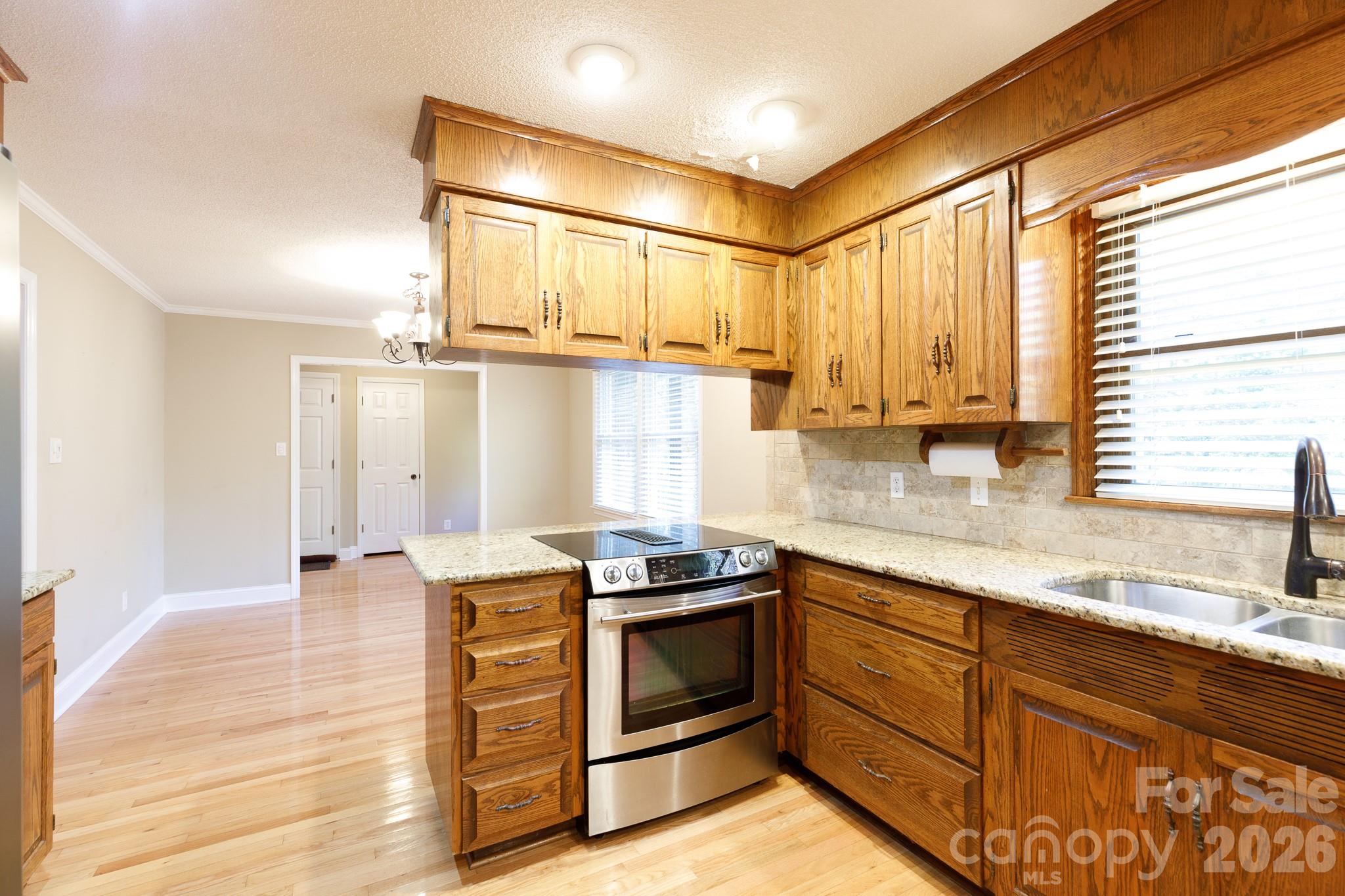 4193 Walker Road Rock Hill, SC 29730 - Photo 21 of 38 a kitchen with stainless steel appliances granite countertop a stove a sink and white cabinets