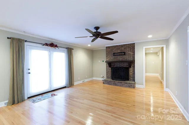 a view of an empty room with a fireplace and a window