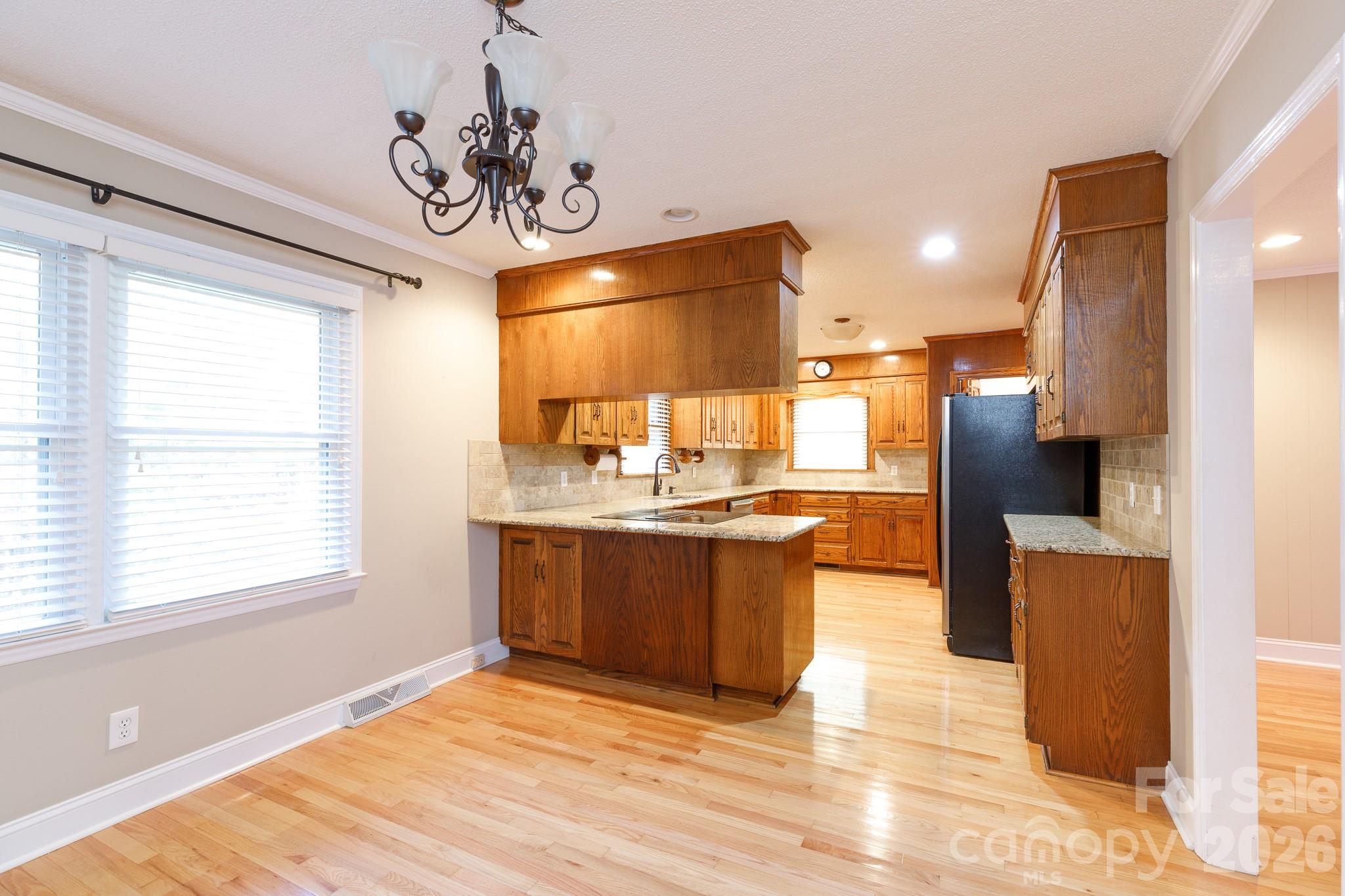 4193 Walker Road Rock Hill, SC 29730 - Photo 8 of 38 a kitchen with stainless steel appliances granite countertop a refrigerator a sink dishwasher a stove with wooden cabinets and floor