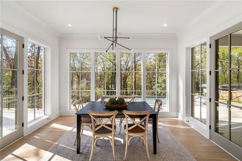 1074 Moores Mill Road Northwest Atlanta, GA 30327 - Photo 24 of 68 a dining room with furniture large windows and wooden floor