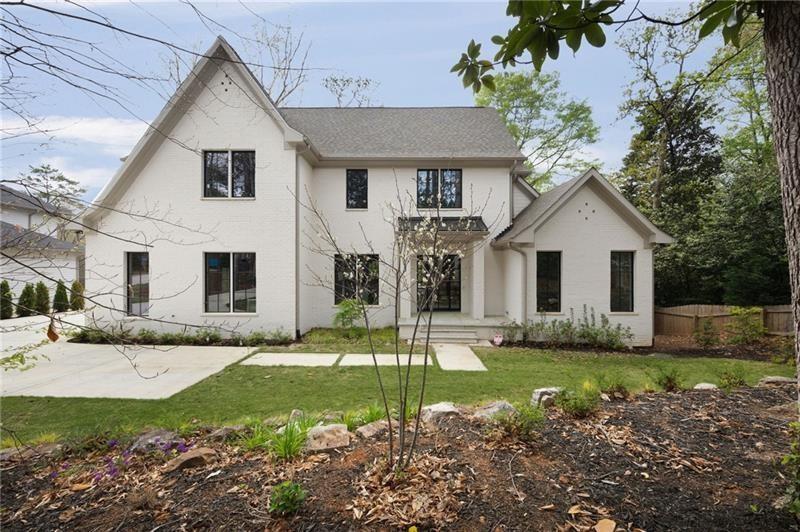 1074 Moores Mill Road Northwest Atlanta, GA 30327 - Photo 4 of 68 a view of a white house with a yard and plants