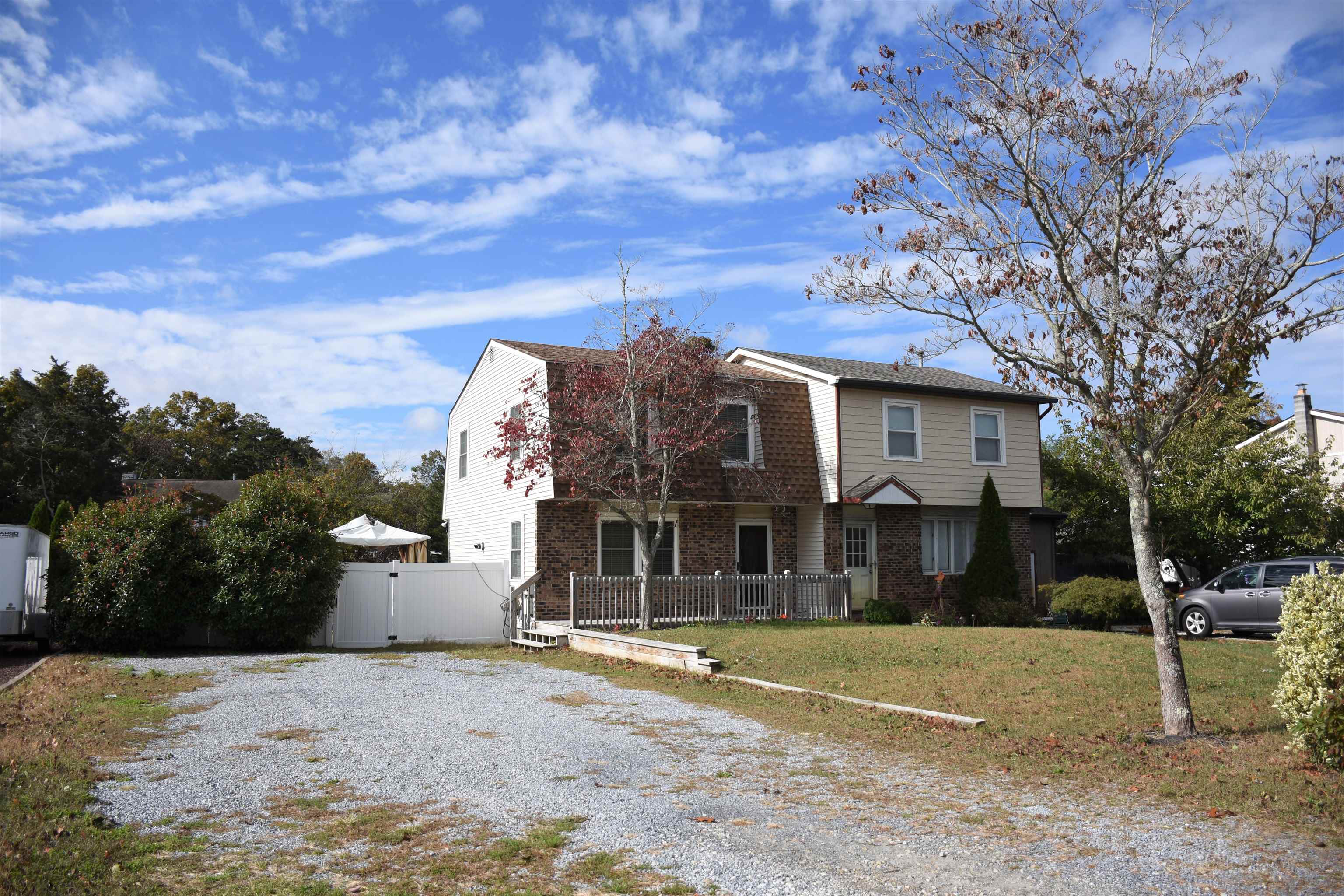 a view of a white house with a yard and large tree