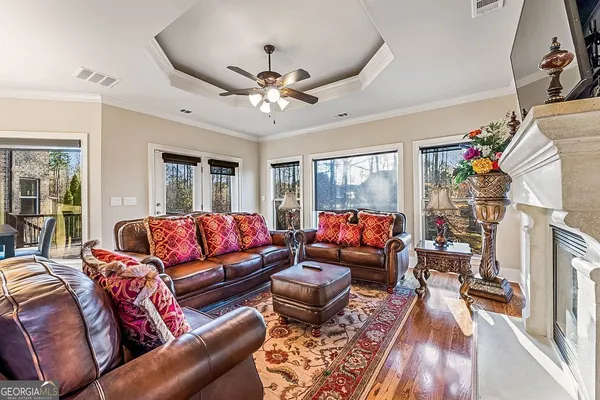 a living room with furniture a wooden floor and next to a window