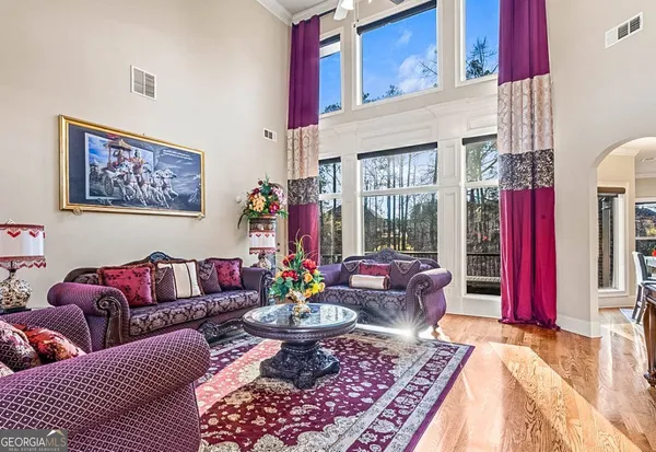 a dining room with furniture a chandelier and wooden floor