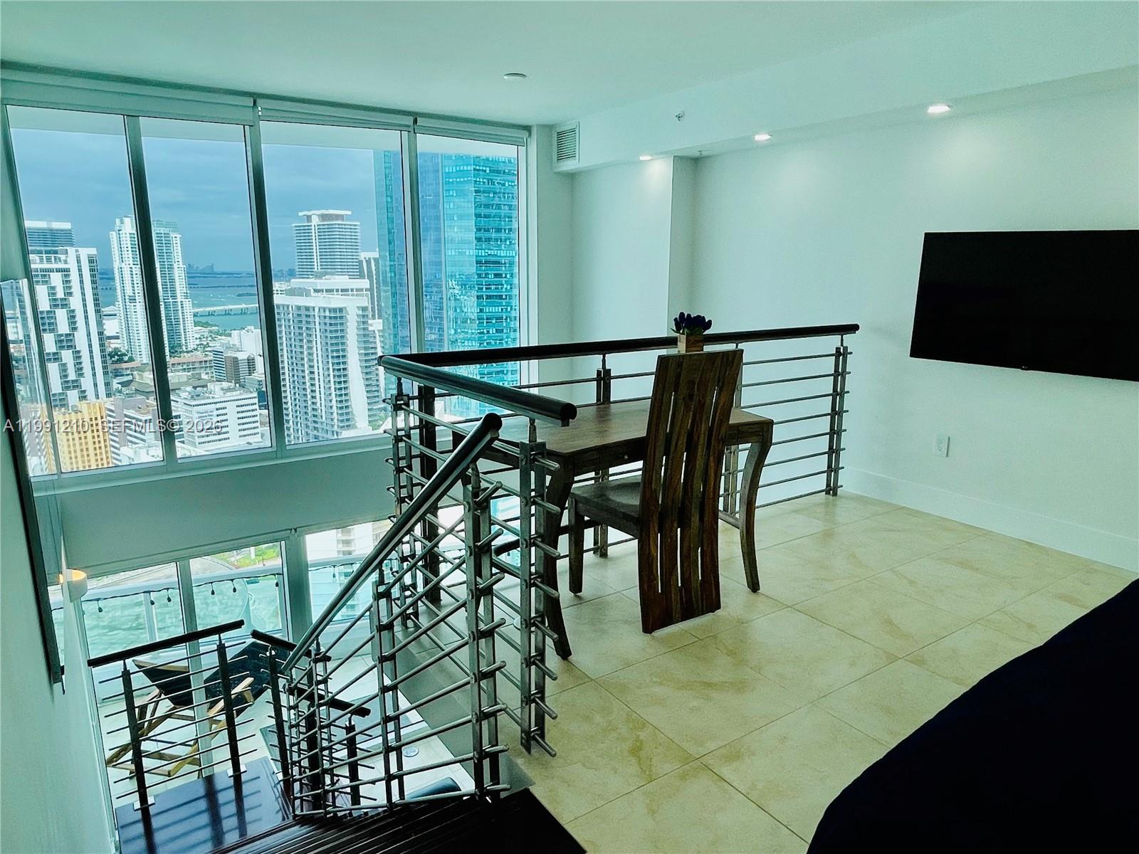 41 Southeast 5th Street, Unit 2305 Miami, FL 33131 - Photo 11 of 56 a view of a dining room with furniture and a potted plant