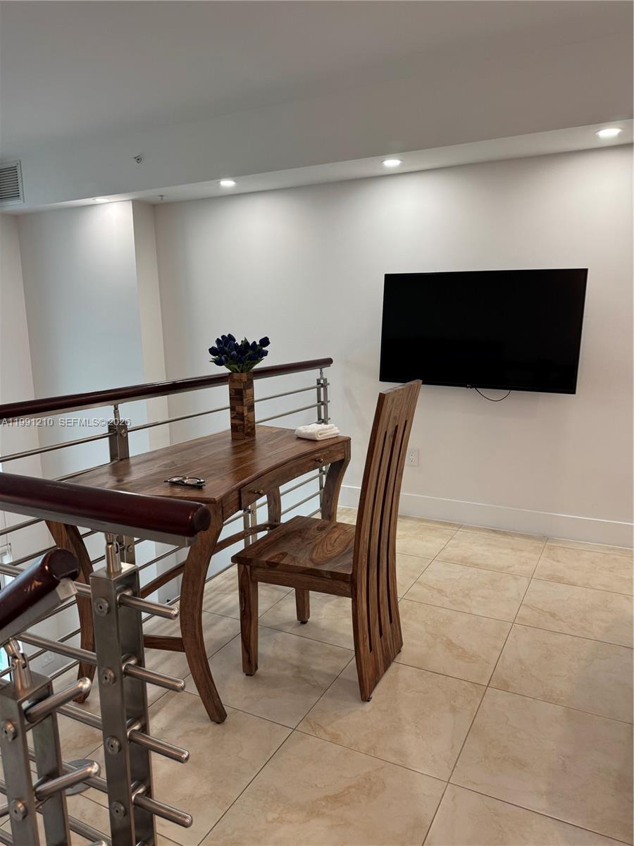 41 Southeast 5th Street, Unit 2305 Miami, FL 33131 - Photo 17 of 56 a dining room with furniture and a flat screen tv